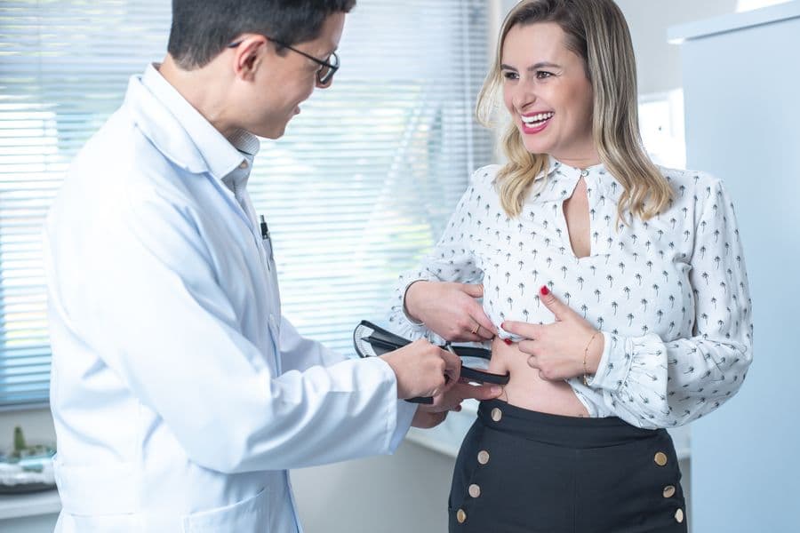 Body Fat Percentage Measurement with Skinfold Calipers Healthcare professional using body fat calipers on a patient to measure body fat percentage — a more precise body composition method than BMI alone